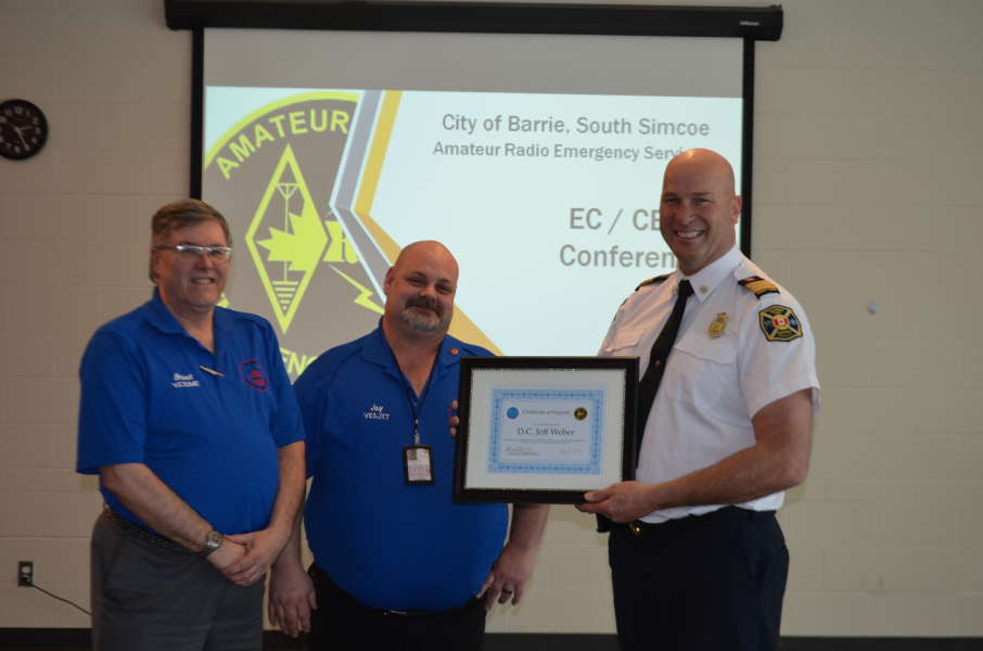 Brant (VE3UME) and Jason (VE3JXT) presenting a certificate of recognition to Deputy Fire Chief Jeff Weber for all of his support